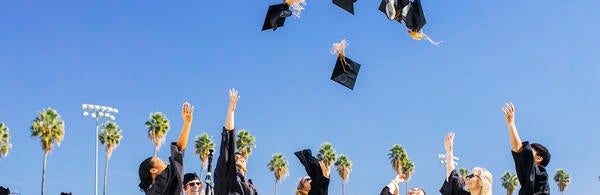 UCR graduates celebrating, throwing hats (c) UCR