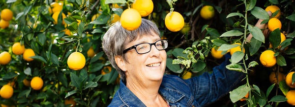 woman standing in citrus groves (c) UCR/Kendall Burks 2017