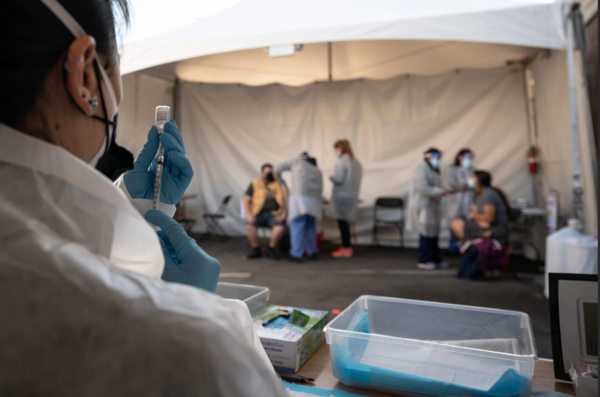 A health care worker prepared a dose of the Pfizer-BioNTech vaccine at a vaccination site in San Francisco on Monday.Credit...Mike Kai Chen for The New York Times