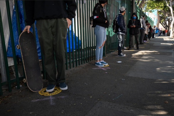 A line to register for a vaccination appointment in San Francisco. Experts say that people who have been inoculated should continue to wear masks to protect others.Credit...Mike Kai Chen for The New York Times