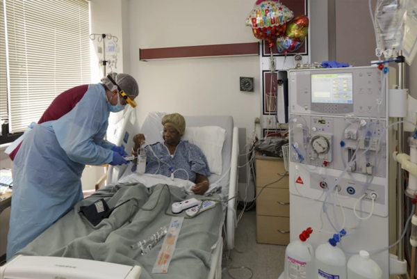 A nurse prepares a COVID-19 patient for dialysis last year.(Irfan Khan / Los Angeles Times)