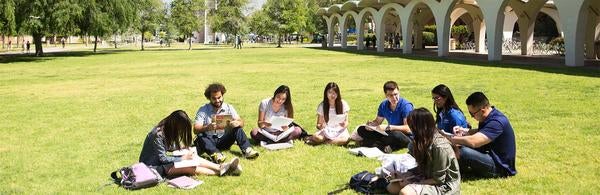 UCR students in front of Rivera Library and Bell Tower