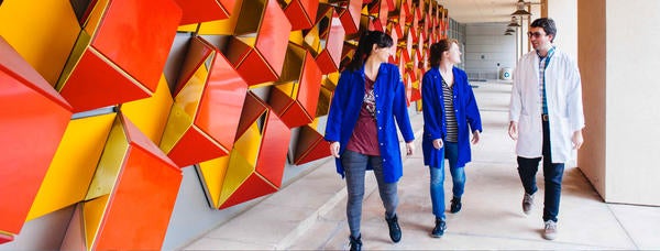 students walking next to art installation